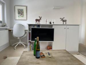 Sala de estar con mesa y botella de vino en Haus-Amici, en Tinnum
