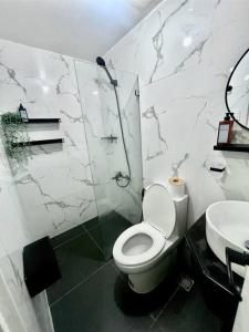 a bathroom with a toilet and a shower and a sink at NAIA T3 -10 PERCENT OFF JUNE GRADUATION PROMO- Fully Interiored 1 BR Unit in Manila