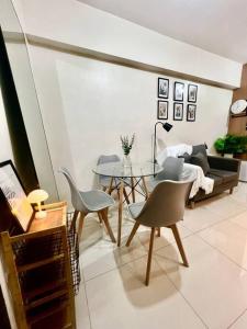 a living room with a couch and a table and chairs at NAIA T3 -10 PERCENT OFF JUNE GRADUATION PROMO- Fully Interiored 1 BR Unit in Manila