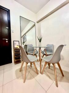 a dining room with a glass table and chairs at NAIA T3 -10 PERCENT OFF JUNE GRADUATION PROMO- Fully Interiored 1 BR Unit in Manila