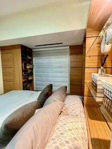 a bedroom with a bed with two pillows on it at NAIA T3 -10 PERCENT OFF JUNE GRADUATION PROMO- Fully Interiored 1 BR Unit in Manila