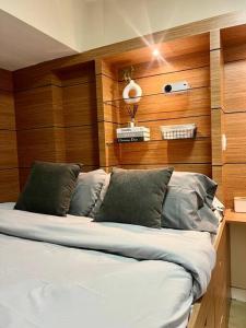 a bed in a room with wood paneled walls at NAIA T3 -10 PERCENT OFF JUNE GRADUATION PROMO- Fully Interiored 1 BR Unit in Manila