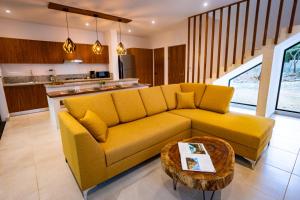 uma sala de estar com um sofá amarelo e uma mesa em Aqua Viva, Pool, AC, Internet, Beach club em Bacalar