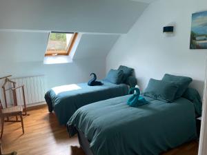 Dwa łóżka w pokoju z dwoma łabędziami w obiekcie Les Maisons des Halles w mieście Cerisy-la-Forêt
