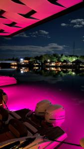 a group of boats in the water with pink lights at Pirates Nest Cottages in Ulcinj