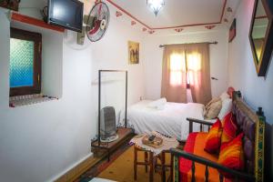 sala de estar con cama y sofá en Dar Chourafa Riad, en Chefchaouen