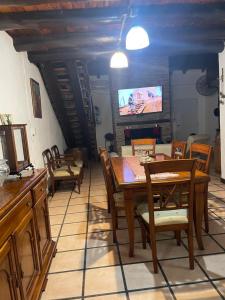 - une salle à manger avec une table, des chaises et une télévision dans l'établissement Fabiana, à Gualeguaychú