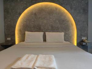 a bedroom with a bed with a large headboard at Hollywood Dannok Hotel in Sadao