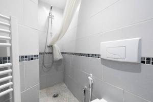 a white bathroom with a shower and a shower at Studio Wifi Métro Paris (Résidence Péri) in Le Pré-Saint-Gervais