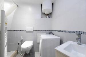 a white bathroom with a toilet and a sink at Studio Wifi Métro Paris (Résidence Péri) in Le Pré-Saint-Gervais