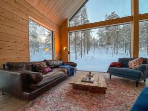 un soggiorno con 2 divani e un tavolo di Kimmelvilla Pyhä - Ski-in, modern design and spectacular scenery a Pyhätunturi