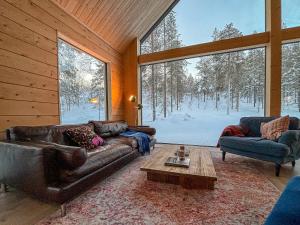 a living room with two couches and a table at Kimmelvilla Pyhä - Ski-in, modern design and spectacular scenery in Pyhätunturi