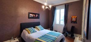 1 dormitorio con cama y ventana en LE NODIER en Lons-le-Saunier