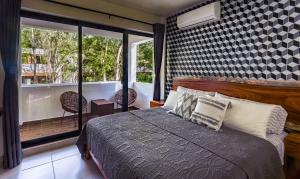 a bedroom with a bed and a large window at Aqua Viva, Pool, AC, Internet, Beach club in Bacalar