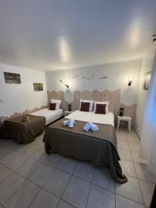 2 bedden in een kamer met 2 bedden, waarvan 1 tweepersoonsbed en 1 eenpersoonsbed. bij Hôtel Le Médiéval in Aigues-Mortes