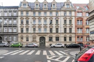 un gran edificio con coches estacionados frente a él en Ruzop Apartament, en Poznan