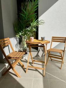 dwa drewniane krzesła i drewniany stół oraz stół i krzesła w obiekcie Nuevo Moderno Apartamento de Lujo w Sewilli