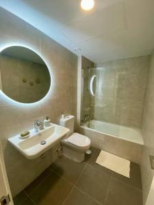 een badkamer met een wastafel, een toilet en een bad bij Nuevo Moderno Apartamento de Lujo in Sevilla
