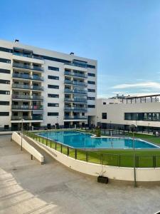 un gran edificio con una piscina frente a él en Nuevo Moderno Apartamento de Lujo en Sevilla