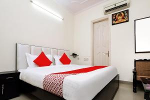 a bedroom with a large bed with red pillows at Collection O Ramji 7 Grand Near Tdi Mall in New Delhi