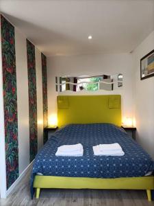1 dormitorio con 1 cama verde y 2 toallas en Studio jacuzzi privé à 8 min à pied de la plage en La Ciotat