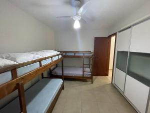 a room with two bunk beds and a ceiling fan at 411- Casa para 8 pessoas 20 metros da Praia Central em Bombinhas in Bombinhas +18 photos