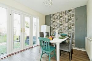 uma sala de jantar com mesa e cadeiras em Gema Home - Charming Canterbury Home with private parking perfect for vans em Kent