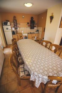 een eetkamer met een tafel en stoelen en een keuken bij Balázs Panzió in Corund