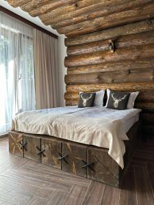 uma cama num quarto com uma parede de madeira em CHALET ELEVEN em Dospat