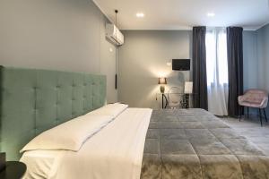 ein Schlafzimmer mit einem großen Bett und einem TV in der Unterkunft Il Cortile Degli Artisti in Marsala