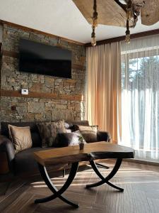 a living room with a couch and a coffee table at CHALET ELEVEN in Dospat