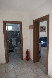a room with a bathroom with a toilet and a fire hydrant at Apartman Mila in Županja