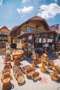 een groep rieten stoelen en tafels voor een winkel bij Balázs Panzió in Corund