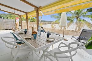 Une table et des chaises en bois sont disponibles sur la terrasse. dans l'établissement Villa Kaz Kreyol, à Les Anses-d'Arlet