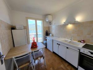 uma cozinha com um balcão, um lavatório e um frigorífico em Location appartement propriano em Propriano