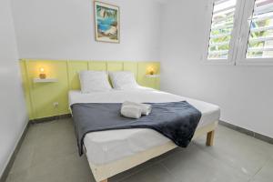 a bedroom with a bed with a blue blanket on it at Villa Kaz Kreyol in Les Anses-dʼArlets