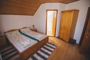 a bedroom with a bed and a wooden door at Balázs Panzió in Corund
