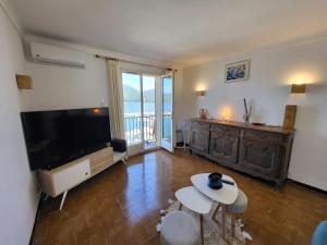 uma sala de estar com uma grande televisão de ecrã plano em Location appartement propriano em Propriano
