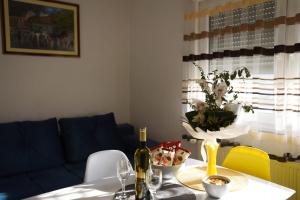 Apartman Mila في زوبانيا: طاولة غرفة الطعام مع إناء من الزهور عليها