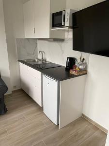 a white kitchen with a sink and a microwave at Appartement Brussels Airport in Machelen