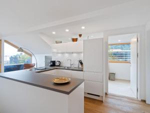 a kitchen with white cabinets and a counter top at Traumhafte Stadtwohnung mit Blick auf den Bodensee in Bregenz
