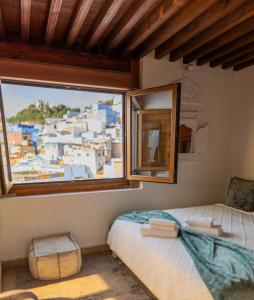 a bedroom with a bed and a large window at Riad Nila in Chefchaouen
