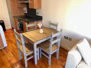 a dining room table with chairs and a kitchen at Central 2 Bedroom Apartment - Fast WIFI - Near Broad Street in Birmingham