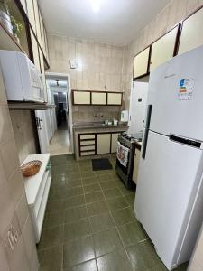a kitchen with a white refrigerator and a stove at Apartamento em Ipanema Melhor localização in Rio de Janeiro