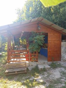 un cobertizo de madera con una maceta en él en Kamp Seosko domaćinstvo Radman, en Herceg-Novi