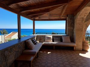 a patio with two couches and a view of the ocean at PETRINO in Keratokampos