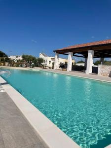 een zwembad met blauw water voor een gebouw bij Boara Resort in Mottola