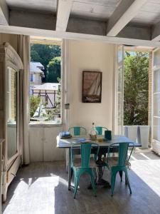 uma sala de jantar com mesa, cadeiras e janelas em 3 Pieces BORD DE MER- Trouville em Trouville-sur-Mer