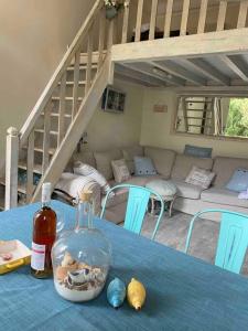 uma mesa com uma toalha de mesa azul com uma garrafa e um sofá em 3 Pieces BORD DE MER- Trouville em Trouville-sur-Mer