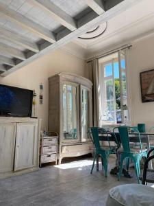 um quarto com uma mesa e cadeiras e uma televisão em 3 Pieces BORD DE MER- Trouville em Trouville-sur-Mer